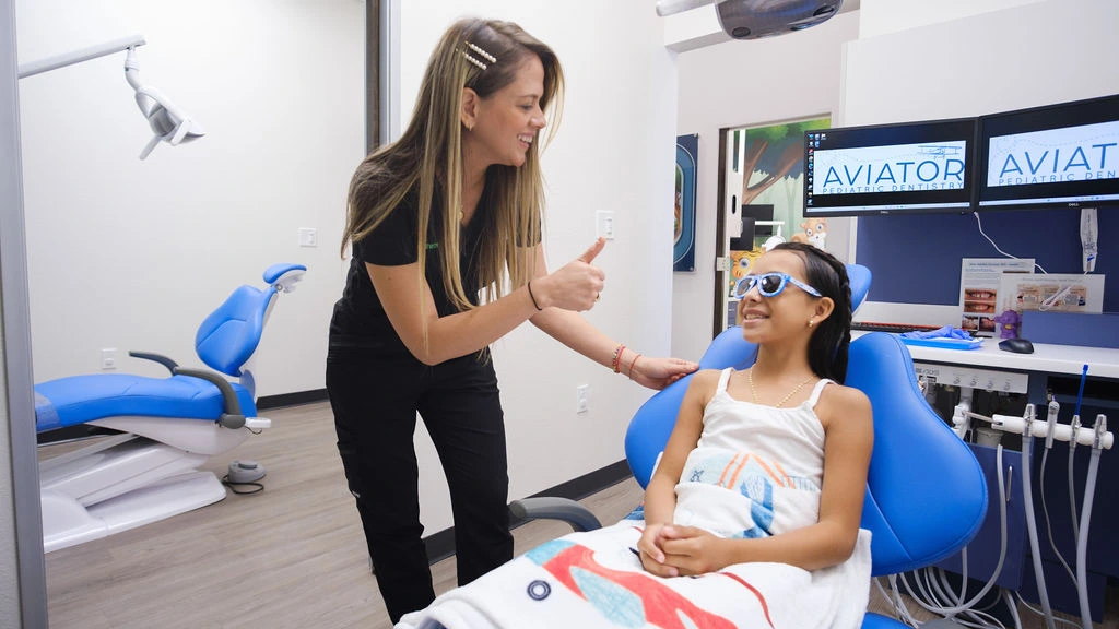 Dental assistant comforting a nervous child before their dental appointment.